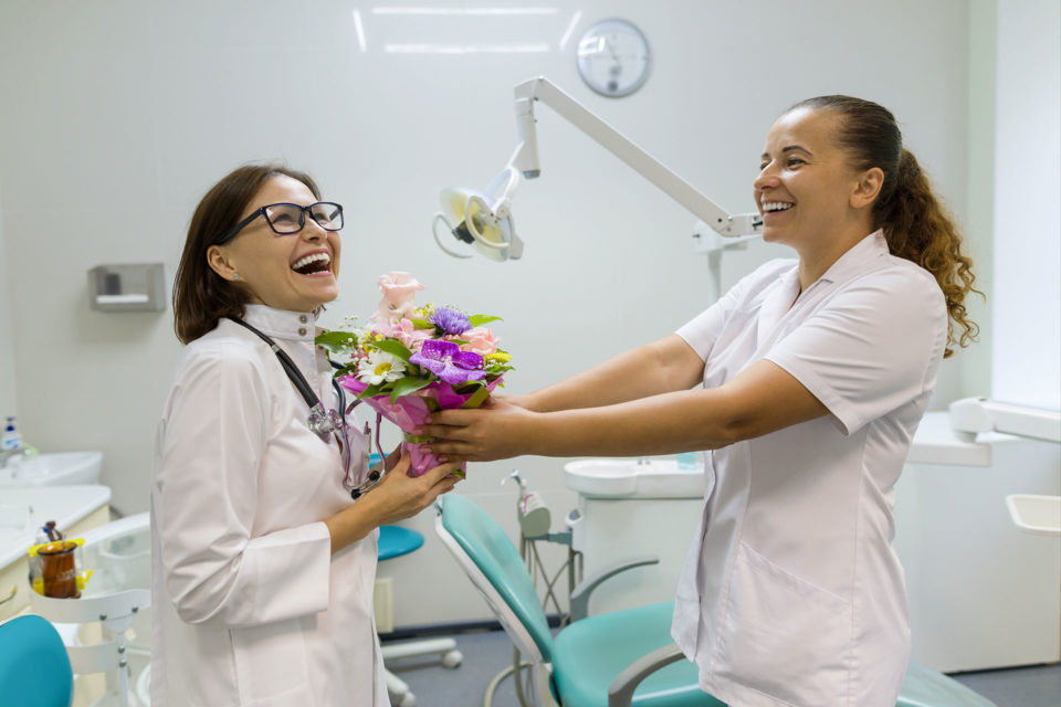 nurse handing flowers to doctor