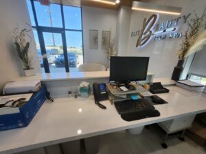 Medical office Plano TX reception desk with marble countertops and modern medical spa branding at National Medical Center