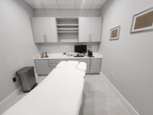 Medical office Plano TX fully equipped treatment room with medical bed and built-in cabinetry for healthcare services